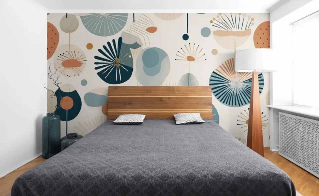Tête de lit en bois devant un mur orné d'une peinture graphique abstraite aux formes organiques et aux couleurs douces.