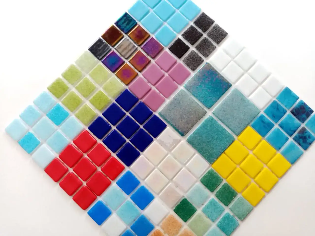 Mosaicos de diferentes tipos de gresite para piscinas, en una variedad de colores y texturas, dispuestos en forma de diamante.