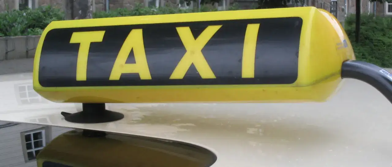 Gelbes TAXI-Schild auf einem Auto. Perfekt f&uuml;r eine taxi kurzstrecke.