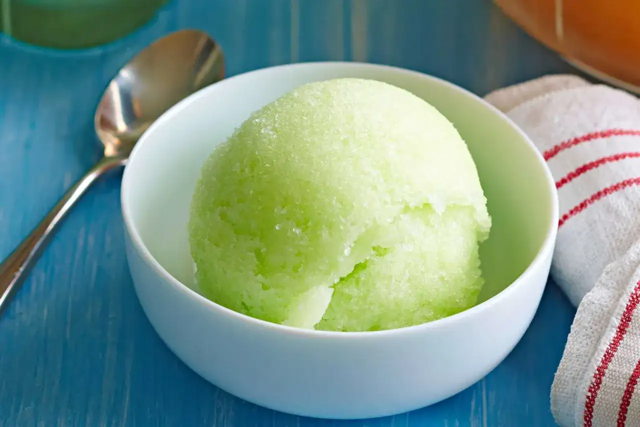 Zielony sorbet w białej miseczce, gotowy do podania. Idealny przepis na to, jak zrobić sorbet w upalny dzień.