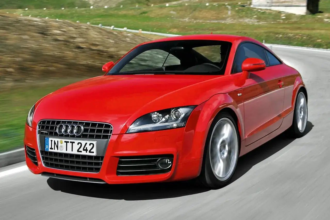 Roter Audi TT 2.0 Coupé fährt auf einer kurvigen Straße.