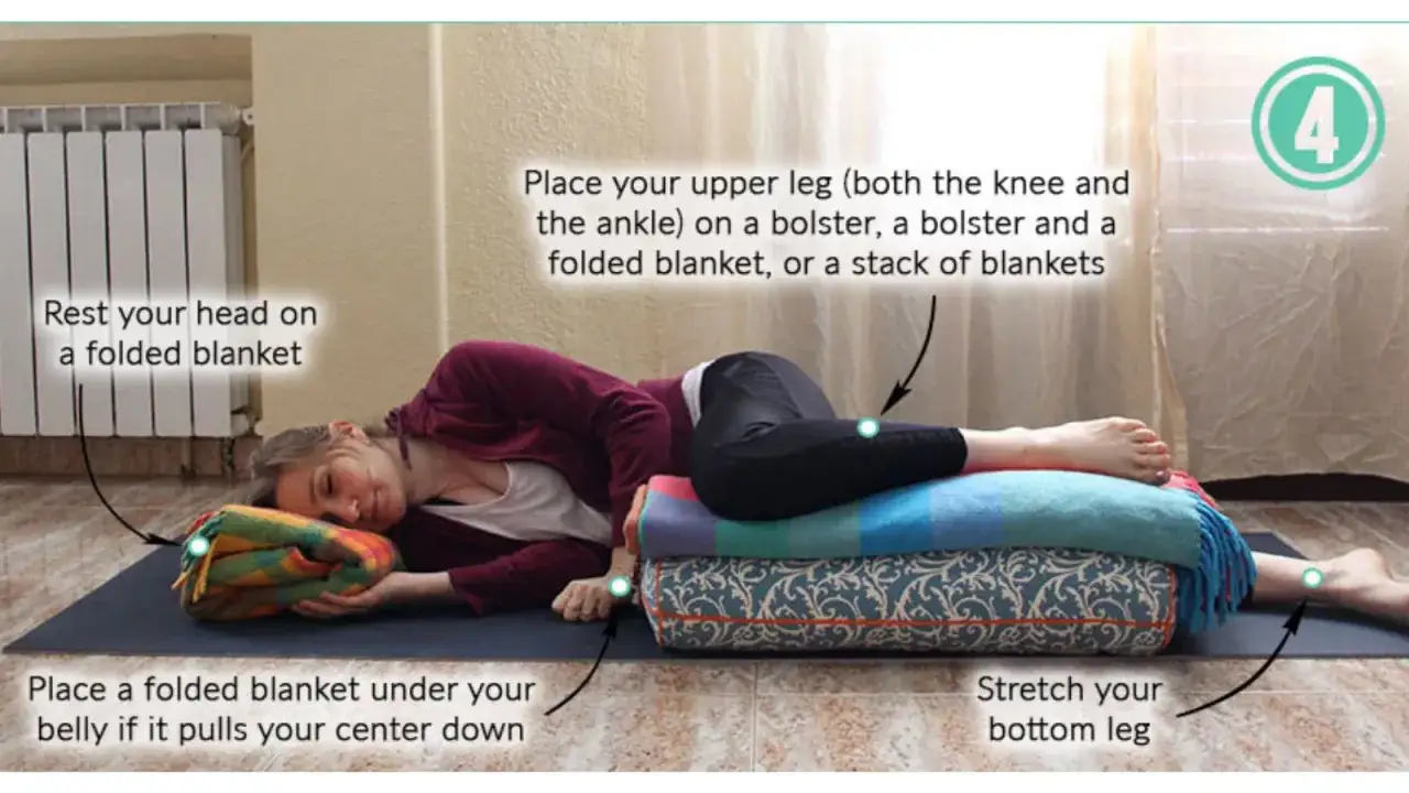 Gravid kvinna i avslappnande graviditetsyoga-position, med stöd av filtar och bolster.