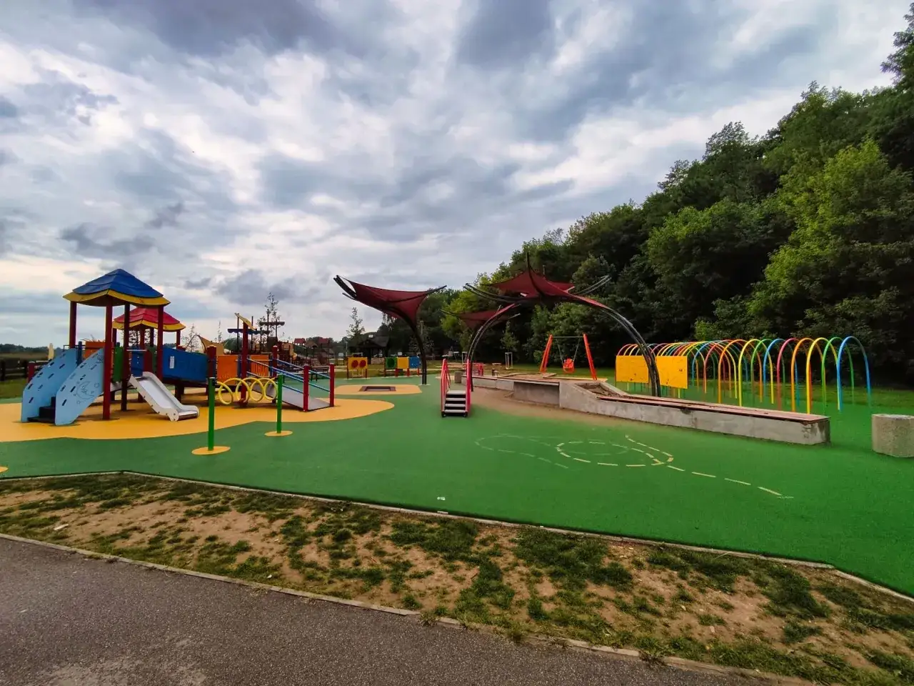Kolorowy plac zabaw w Rzeszowie oferuje mnóstwo atrakcji dla dzieci: zjeżdżalnie, huśtawki, tunele i ścianki wspinaczkowe.