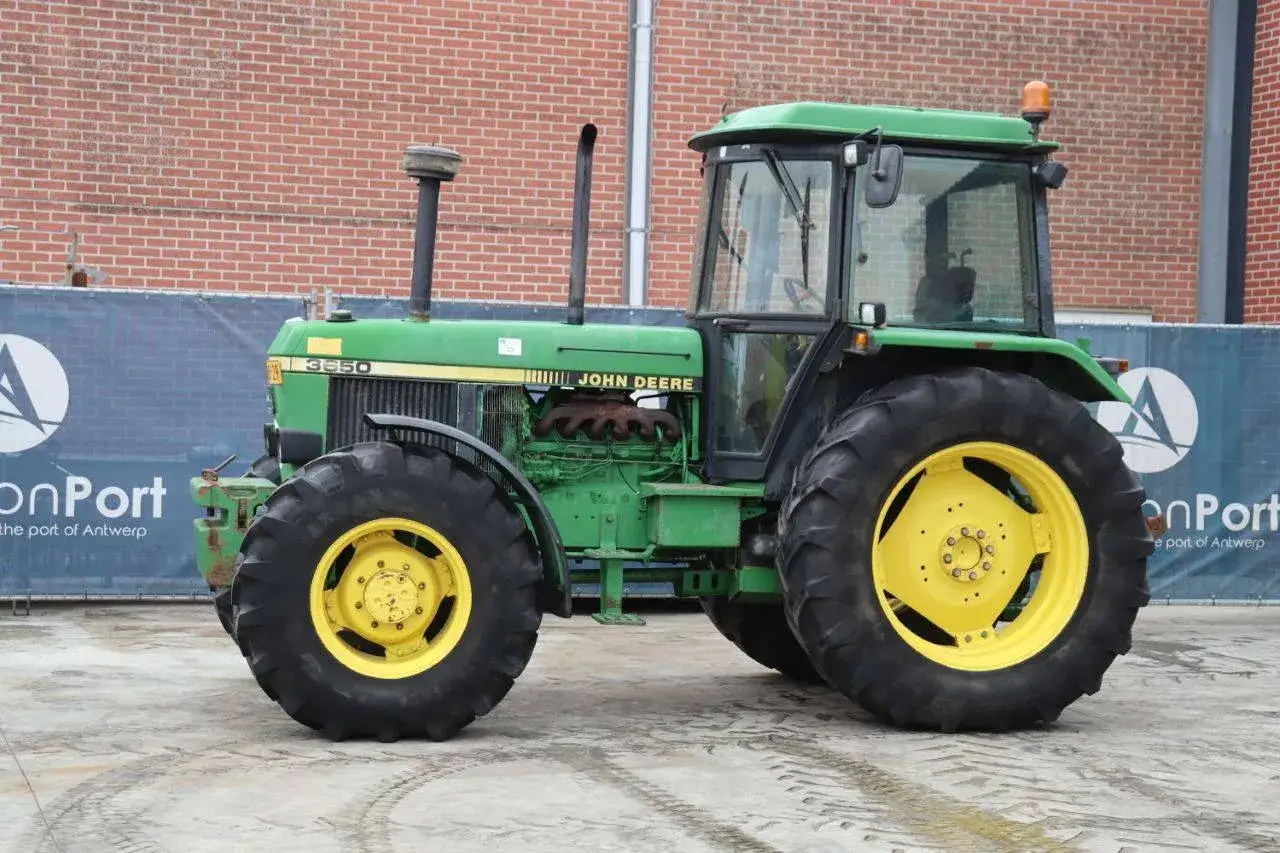 Zielony John Deere 3650 z żółtymi felgami, gotowy do pracy na polu.