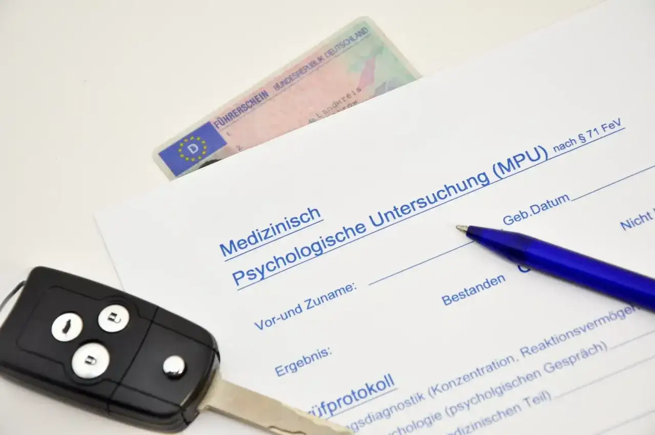 F&uuml;hrerschein, Autoschl&uuml;ssel und MPU-Formular. Ein Stift liegt bereit, um das Ergebnis der Untersuchung zu dokumentieren, die auch den Umgang mit Alkohol pr&uuml;ft.