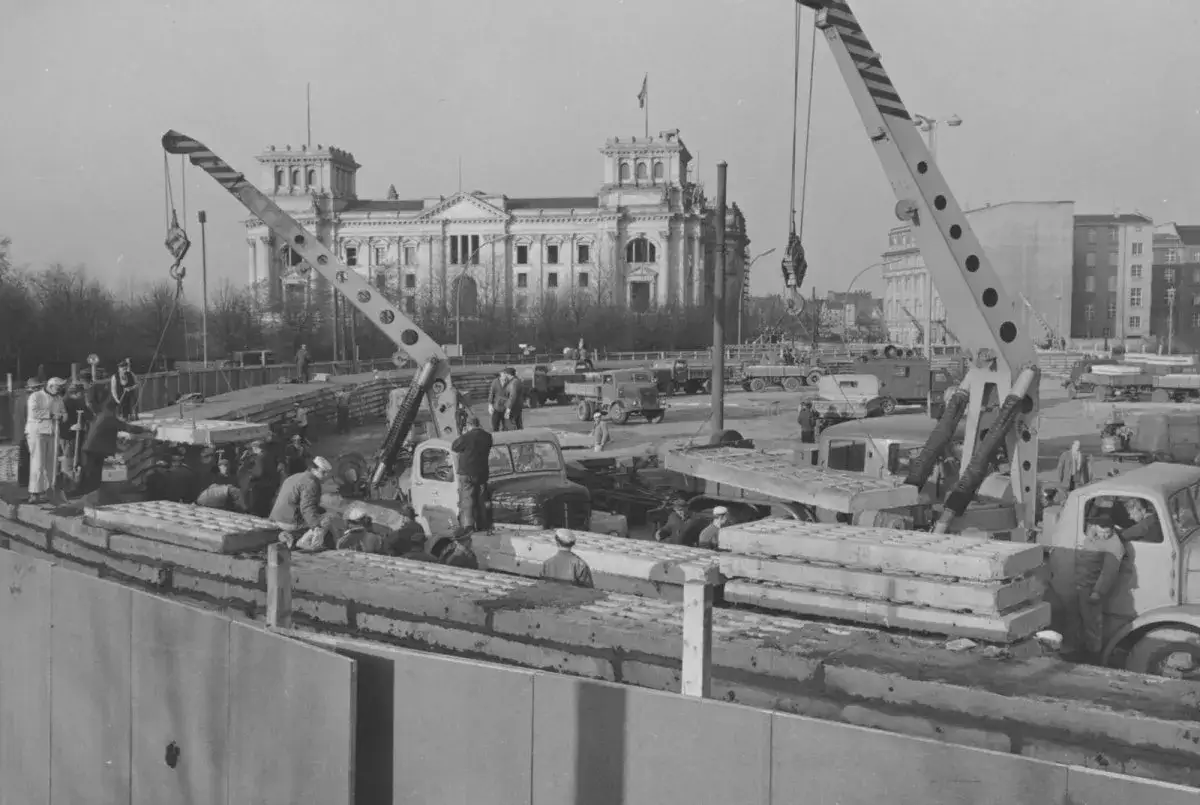 Bauarbeiten am Reichstag, Kräne heben Betonplatten, symbolisch für eine geteilte, bipolare Welt.