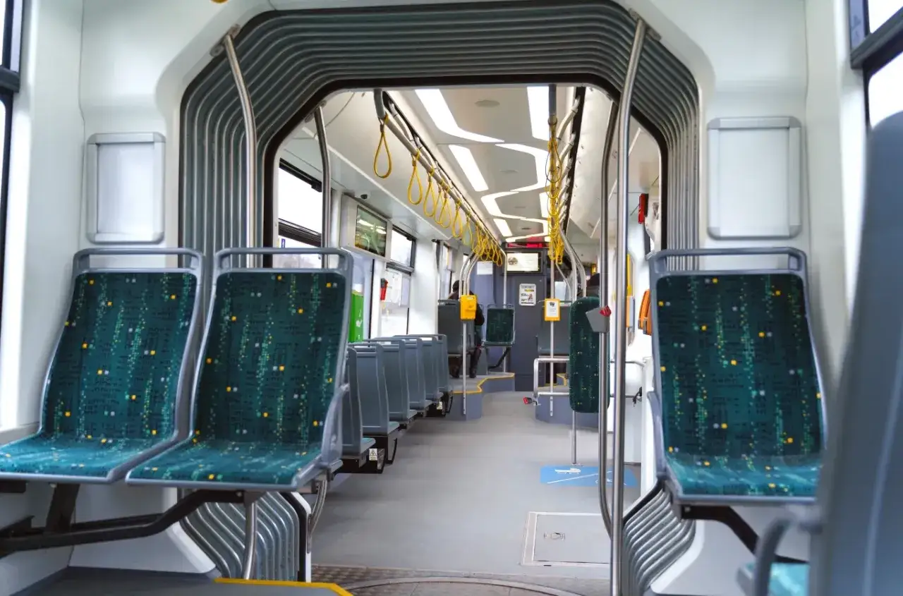 Wnętrze tramwaju z zielonymi siedzeniami. Idealne miejsce na darmowe przejazdy MPK dla emeryt&oacute;w, by zwiedzać miasto.