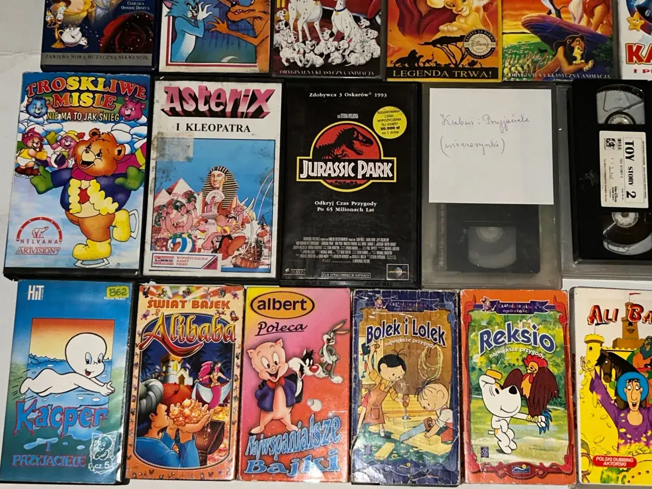 Kolekcja kaset VHS z filmami dla dzieci z lat 90.: Troskliwe Misie, Asterix, Jurassic Park, Casper, Bolek i Lolek, Reksio i inne.