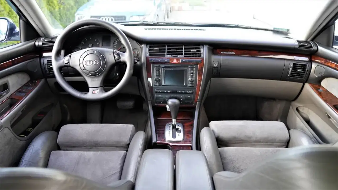 Wnętrze Audi A8 D2 4.2 z drewnianymi wstawkami i skórzaną tapicerką.