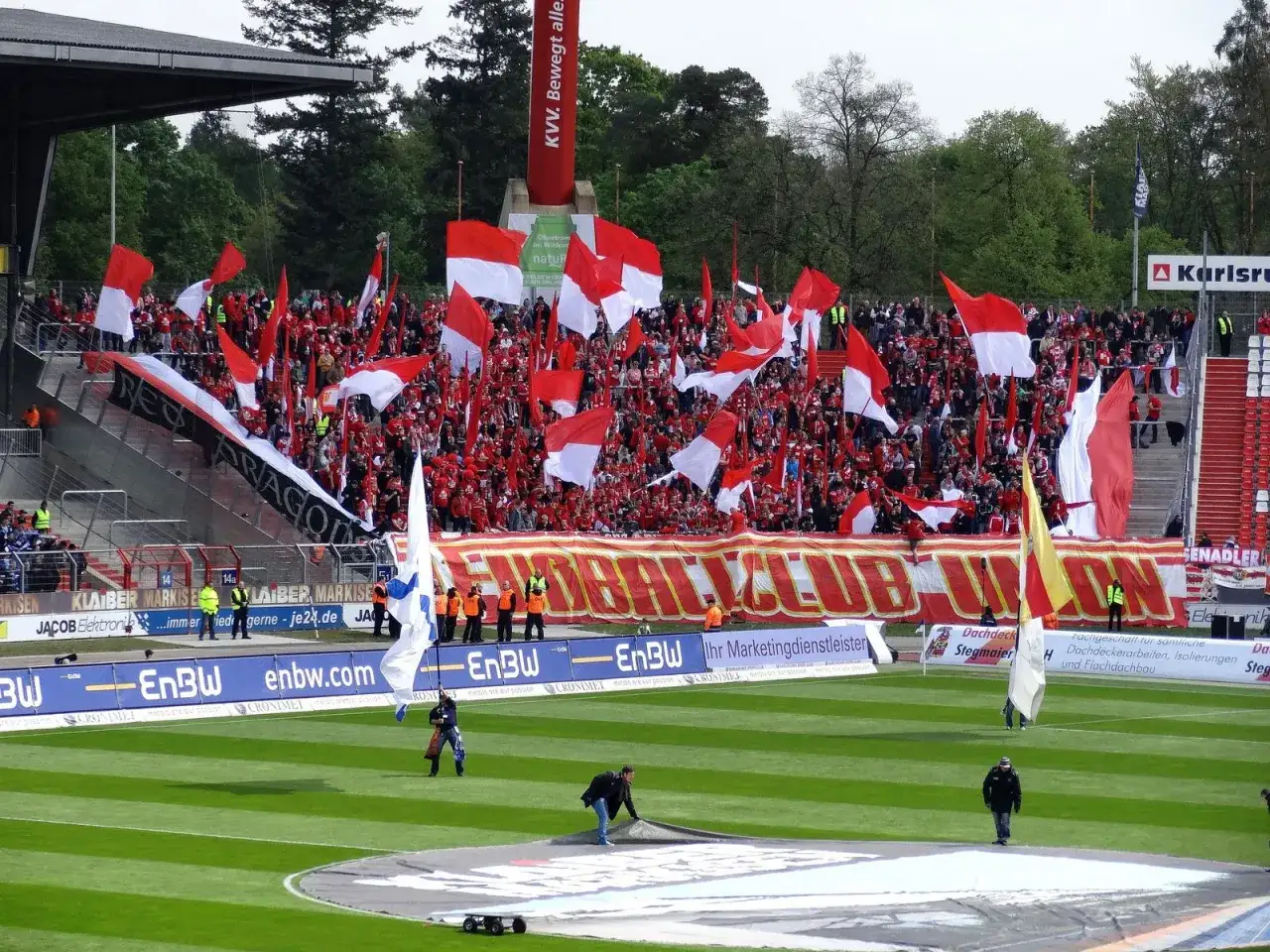 Tysiące kibiców Karlsruher SC z flagami w barwach klubu na trybunach.