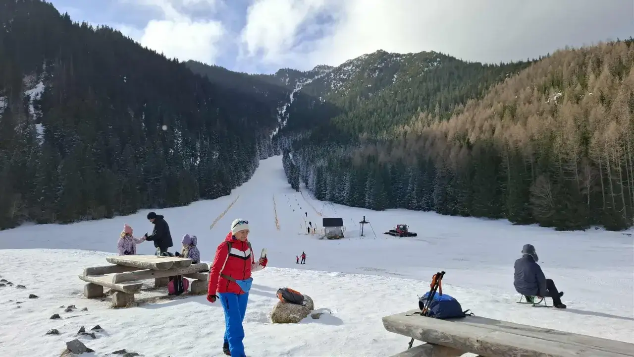 Rodzina odpoczywa na tle stoku narciarskiego, gdzie kiedyś mogły wystąpić największe lawiny w Polsce.