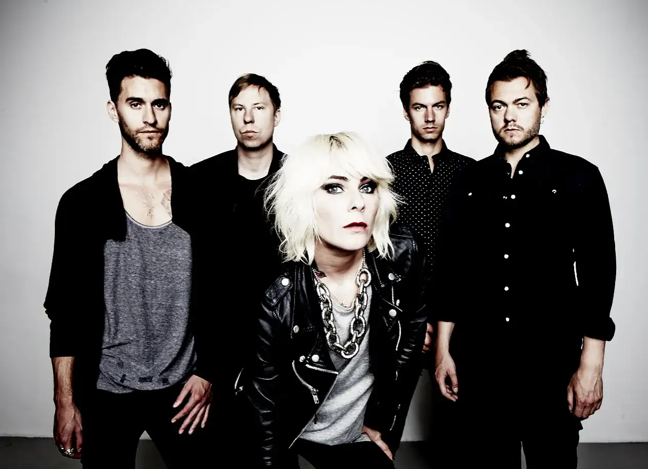 Medlemmar av The Sounds poserar tillsammans. Frontfiguren med blont hår och läderjacka fångar blicken, omgiven av sina bandmedlemmar.