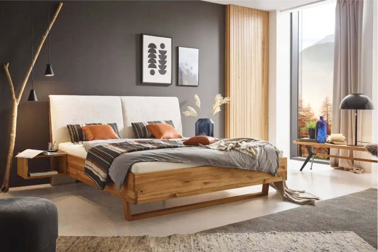 Modernes Schlafzimmer mit anthrazit Wand, Holzbett und gemütlicher Bettwäsche. Dekorative Bilder und eine Lampe schaffen eine einladende Atmosphäre.