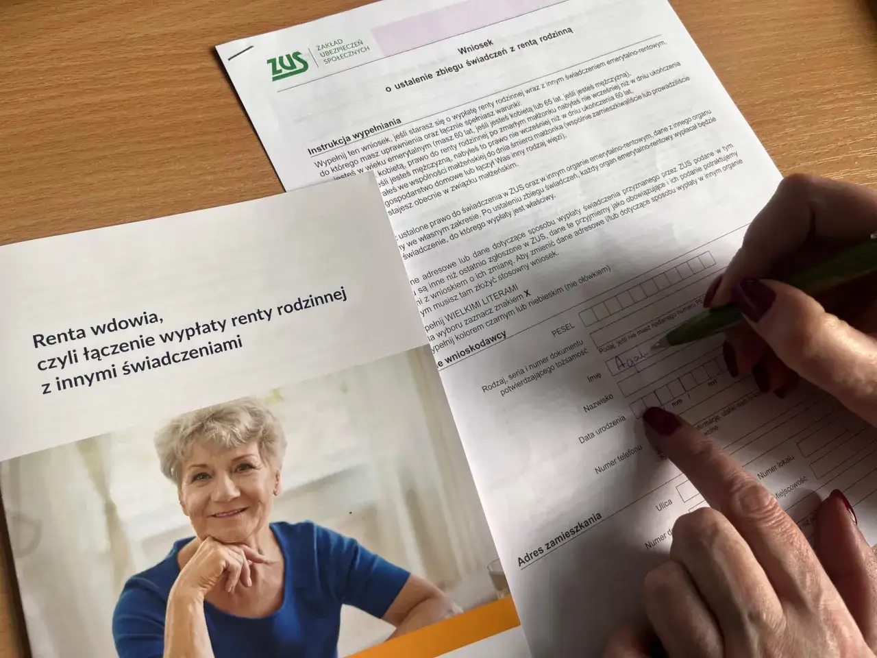 Uśmiechnięta starsza pani wypełnia wniosek do ZUS o rentę rodzinną, czyli emeryturę po mężu.