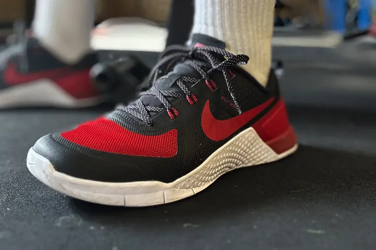 Czarne buty Nike Metcon z czerwonymi akcentami, idealne do treningów. Metcon crossfit co to znaczy? To buty stworzone do wszechstronnych ćwiczeń.