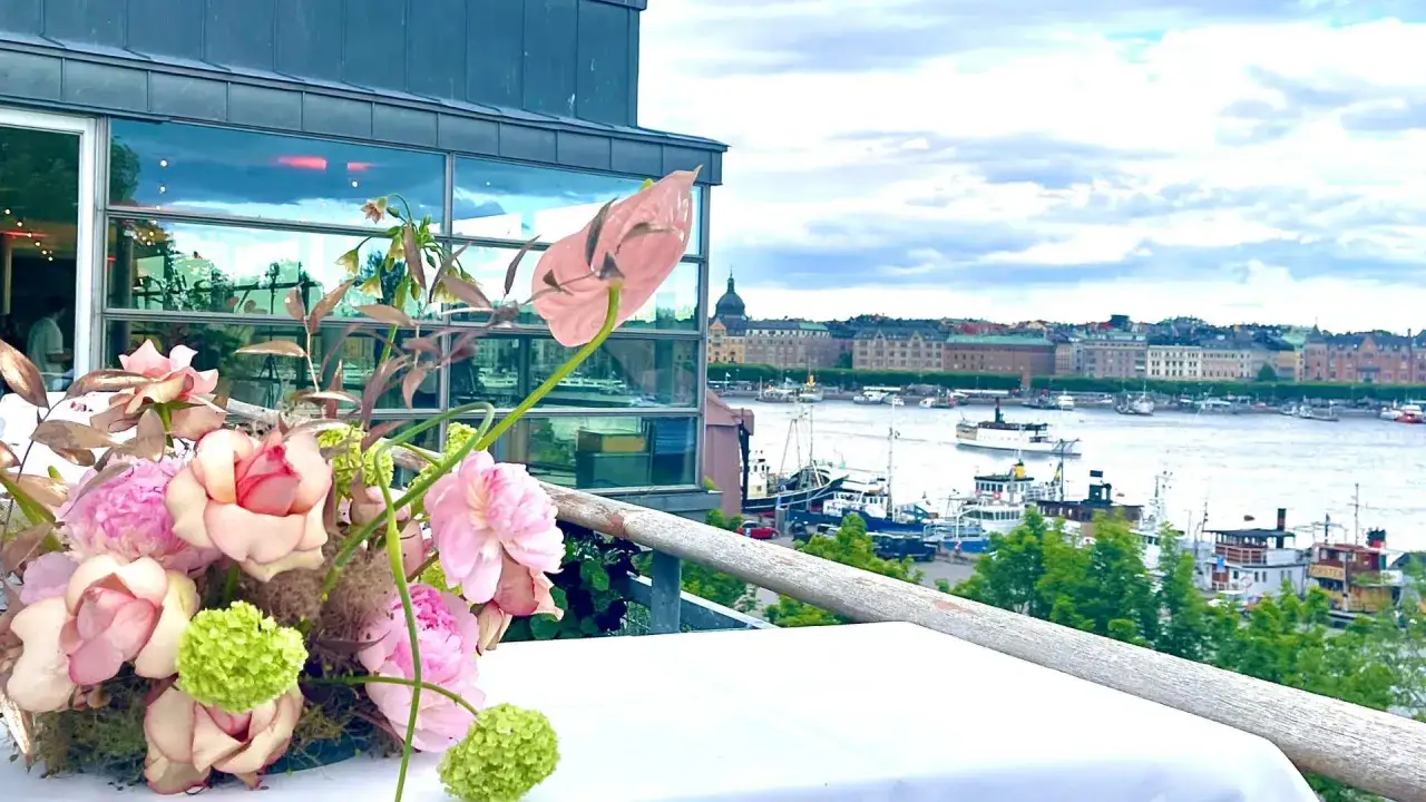 Blommor på bordet vid cafe Skeppsholmen med utsikt över Stockholms inlopp och båtar.