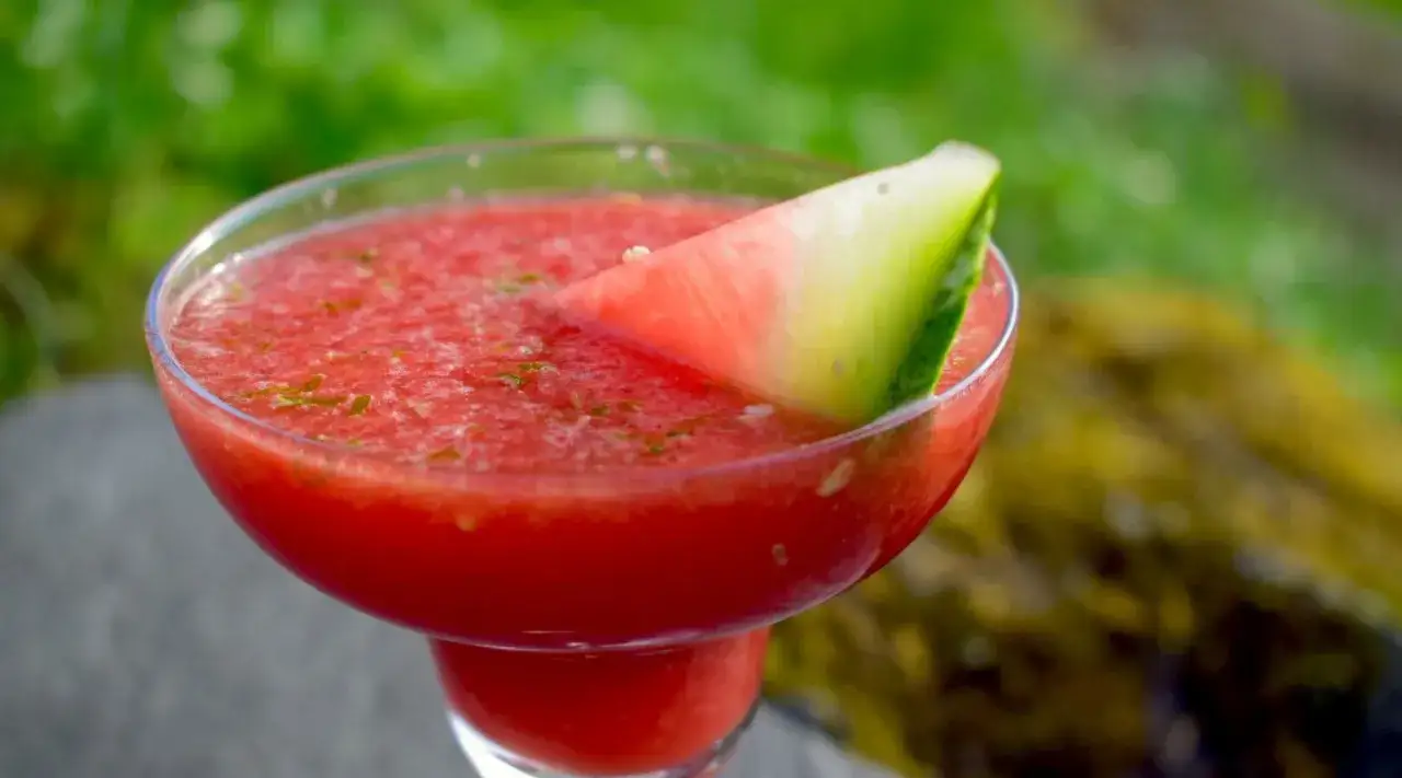 En svalkande watermelon daiquiri, garnerad med en bit vattenmelon, perfekt f&ouml;r en varm sommardag.