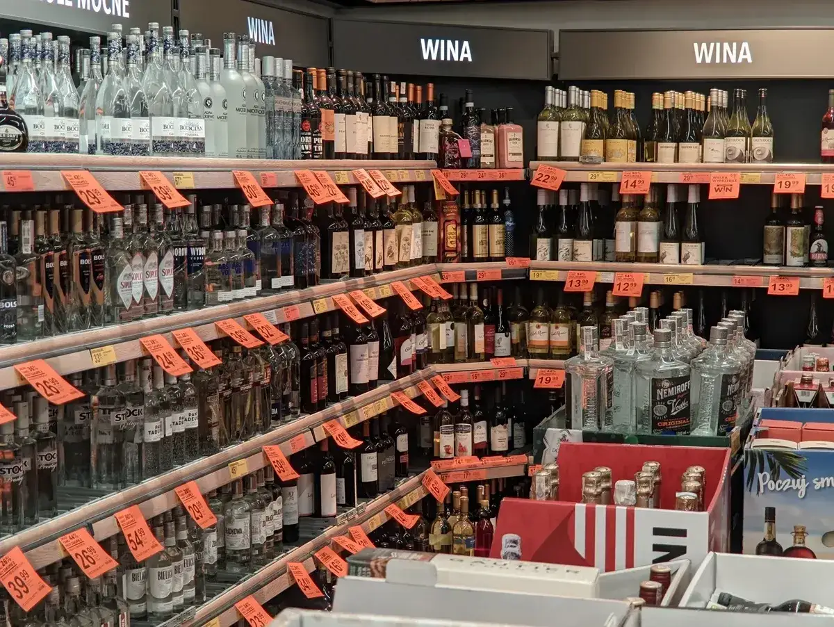 Półki sklepowe uginają się od butelek z wódkami i winami. Widać popularne marki, jak BOLS, Soplica, Wyborowa, Stock, Nemiroff. Wiele z nich ma **bykowe** ceny.
