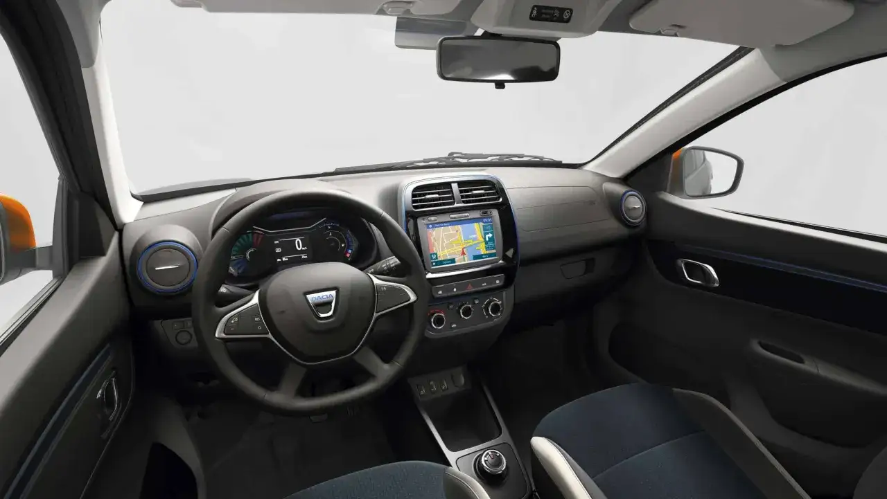 Wnętrze Dacia Spring. Cyfrowy wyświetlacz, ekran multimedialny z nawigacją i kierownica z logo marki. Sprawdź atrakcyjną dacia spring cena!