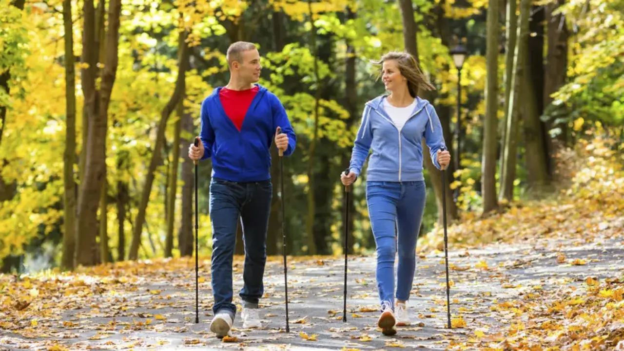 Osoba uprawiająca nordic walking lub szybki spacer w parku