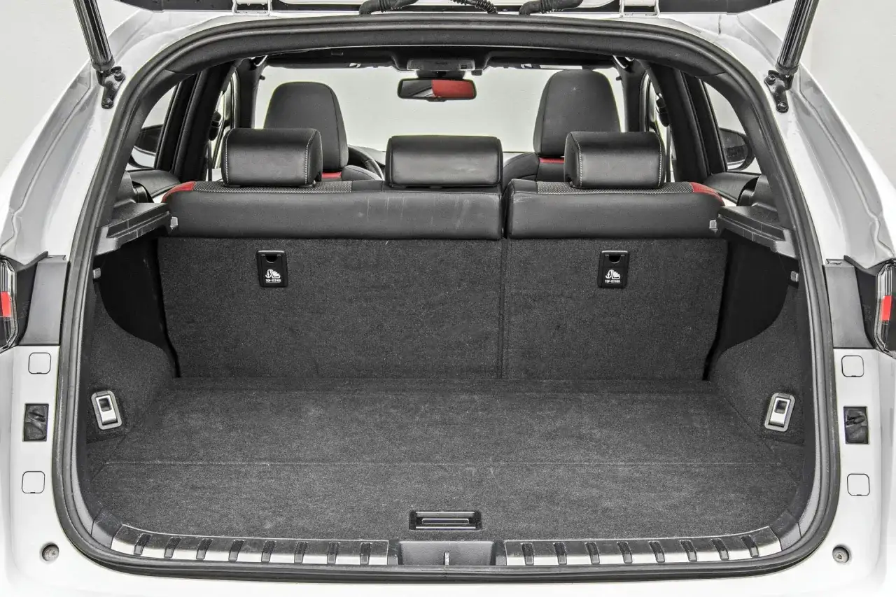 Pusta przestrzeń bagażowa w Lexusie NX350h, gotowa na podróż. Widoczne tylne siedzenia i mocowania ISOFIX.