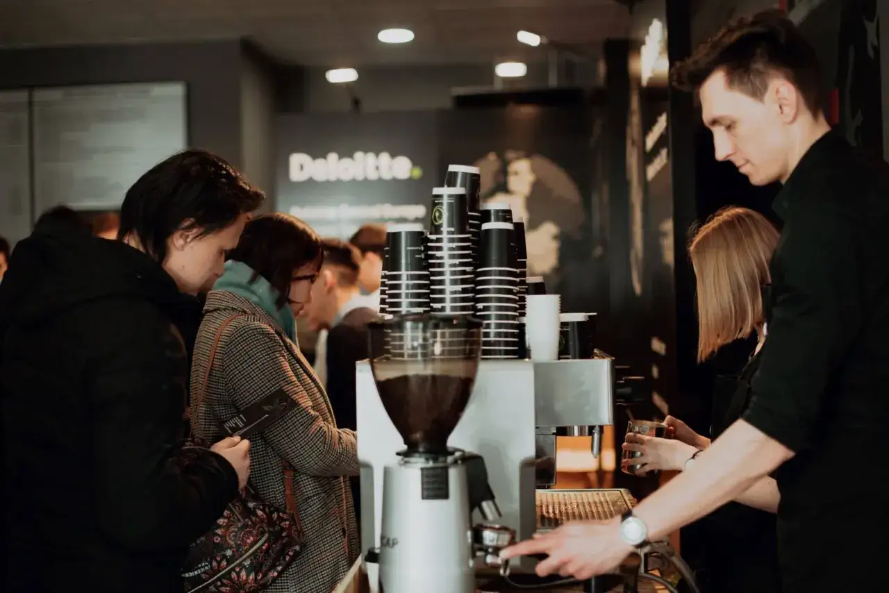 Profesjonalny barista przygotowuje kawę, inspirując do tego, jak zaplanować stylowy kącik kawowy (coffee bar).