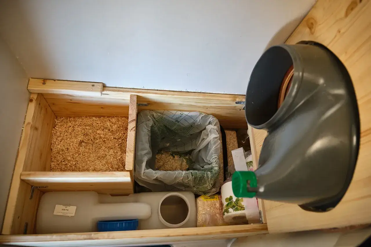 Compartiment de sciure, sac pour toilettes sèches camping car, réservoir d'eau et rouleau de papier.