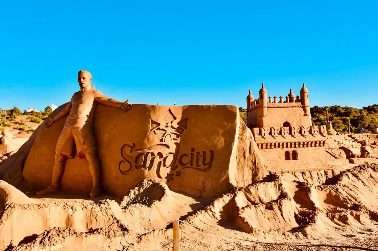 Sandskulptur von Cristiano Ronaldo und einer Burg bei Sand City Algarve.