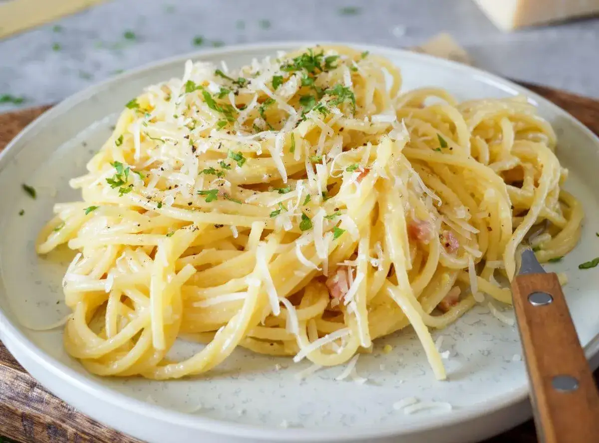 Ein Teller cremiger Spaghetti Carbonara, bestreut mit Parmesan und Petersilie. Ein Klassiker, der immer schmeckt.
