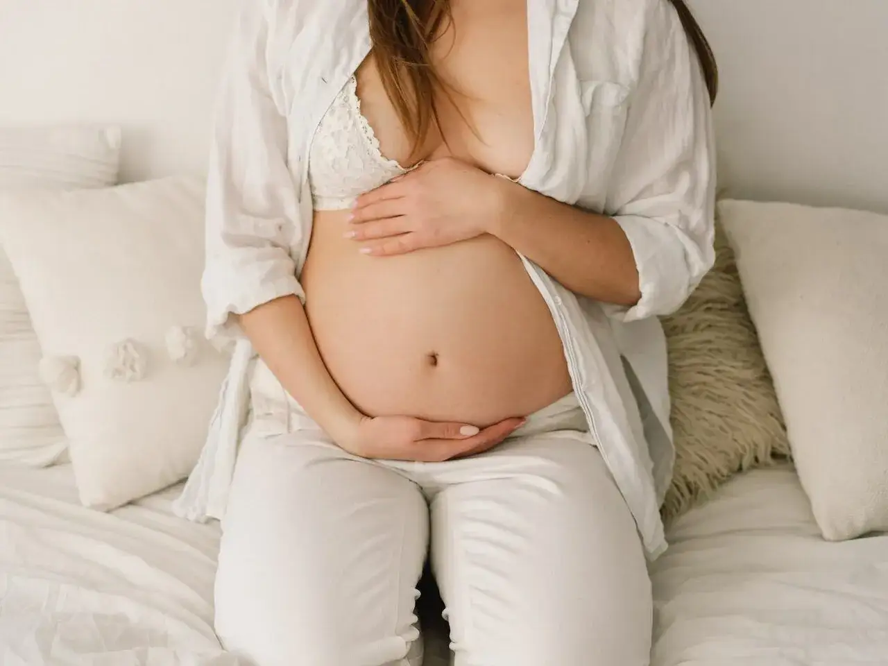 Czekając na poród, brzuch opada, a przyszła mama czule go obejmuje.