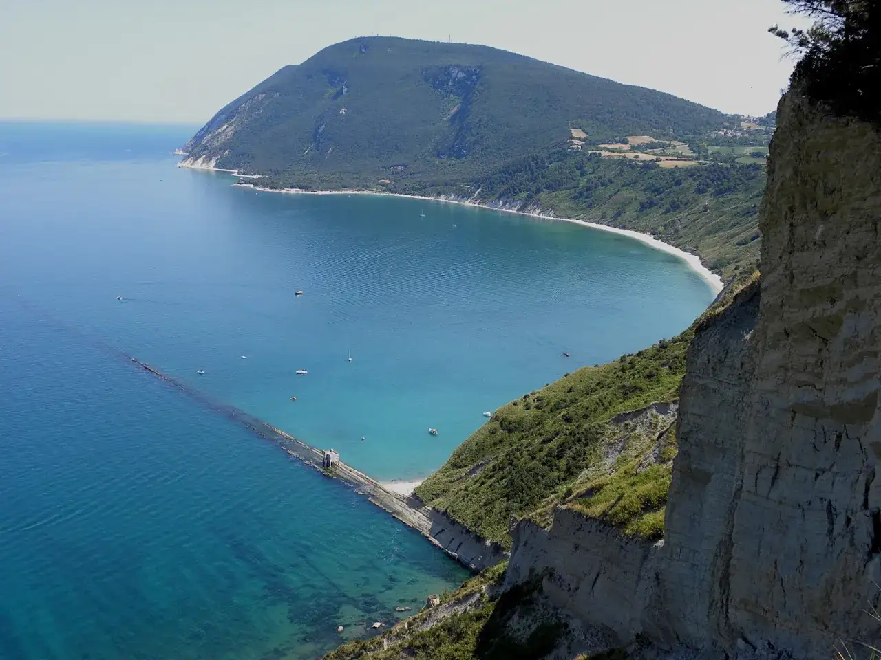 Vista mozzafiato da Gabicce Monte: mare azzurro, spiaggia bianca e una scogliera imponente.