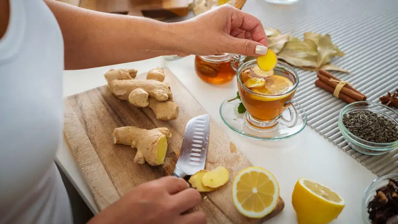 Manos preparando t&eacute; de gengibre con lim&oacute;n y miel. El gengibre sirve para aliviar malestares y dar sabor.