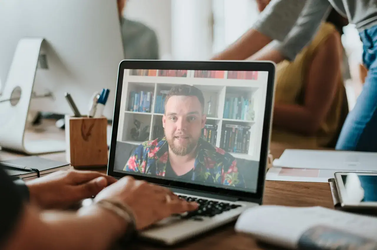 osoba czytająca książkę rozwojową, kurs online na laptopie