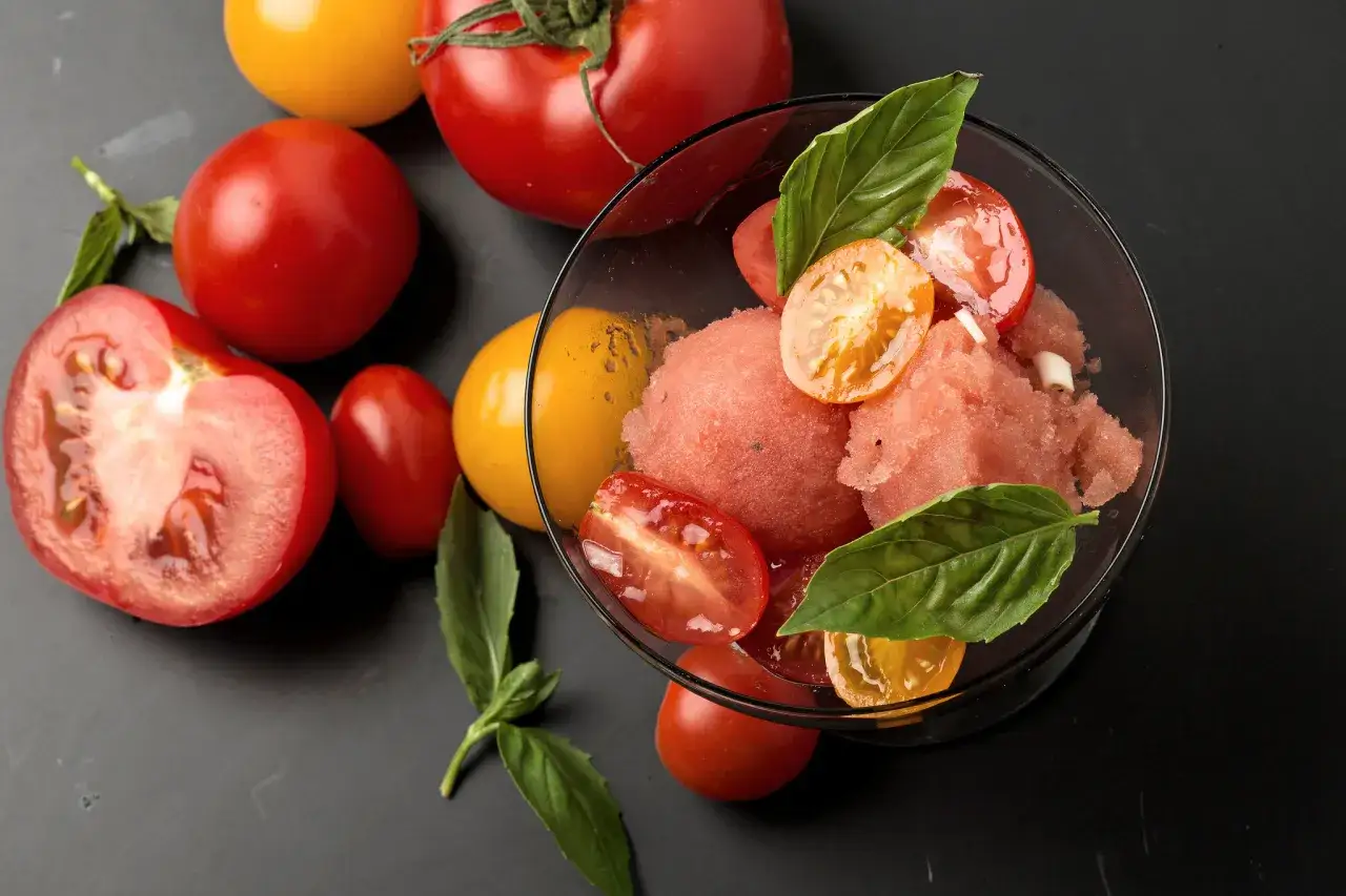 Erfrischendes Tomaten-Eis mit frischen Tomaten und Basilikum garniert. Ein ungew&ouml;hnlicher Genuss!