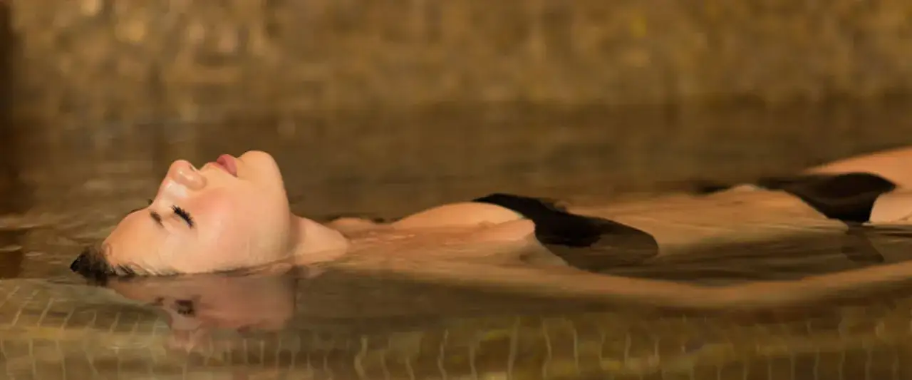 Entspannung pur in den Teplice Therme: Eine Frau treibt im warmen Wasser, die Augen geschlossen, umgeben von einer beruhigenden Atmosph&auml;re.