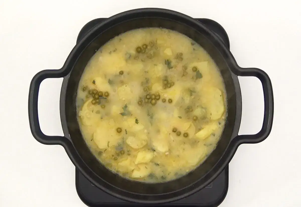Patatas en salsa verde, un plato reconfortante con trozos de patata tierna y guisantes en una salsa cremosa y aromática.