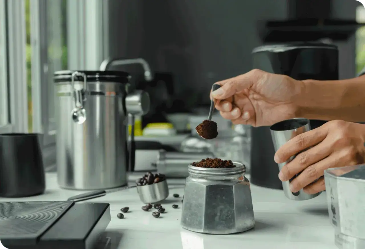 Prepara la tua caffettiera nuova: aggiungi il caffè macinato con un cucchiaino.