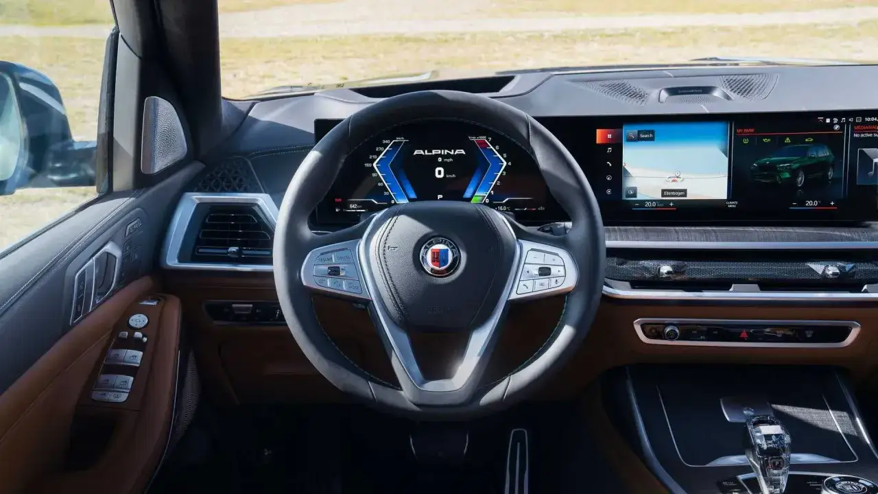 Wnętrze Alpina XB7 z cyfrowym kokpitem, ekranem nawigacji i kierownicą.