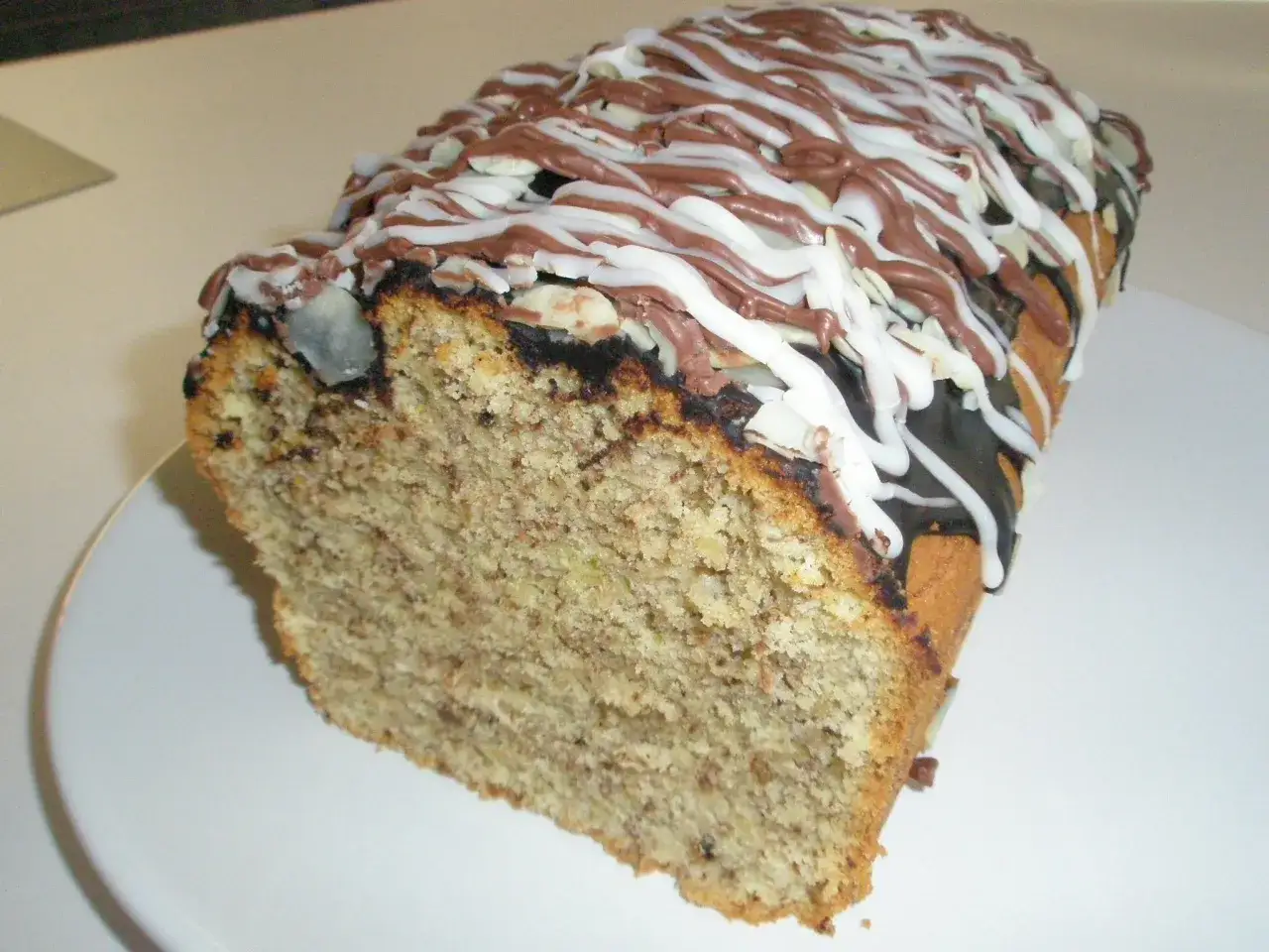 Pyszna babka orzechowa siostry Anastazji, polana czekoladą i lukrem, z kawałkami orzechów.
