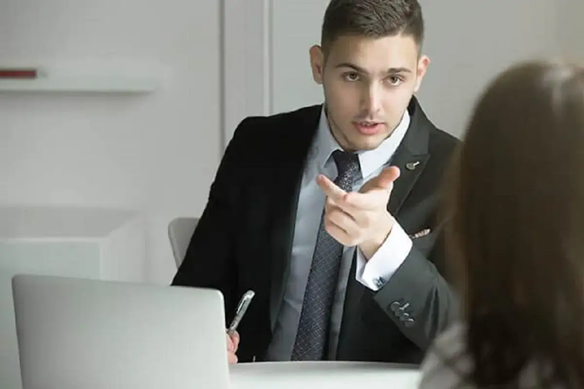 Mężczyzna w garniturze tłumaczy, czy pracodawca może odmówić urlopu. Obok laptop i długopis.