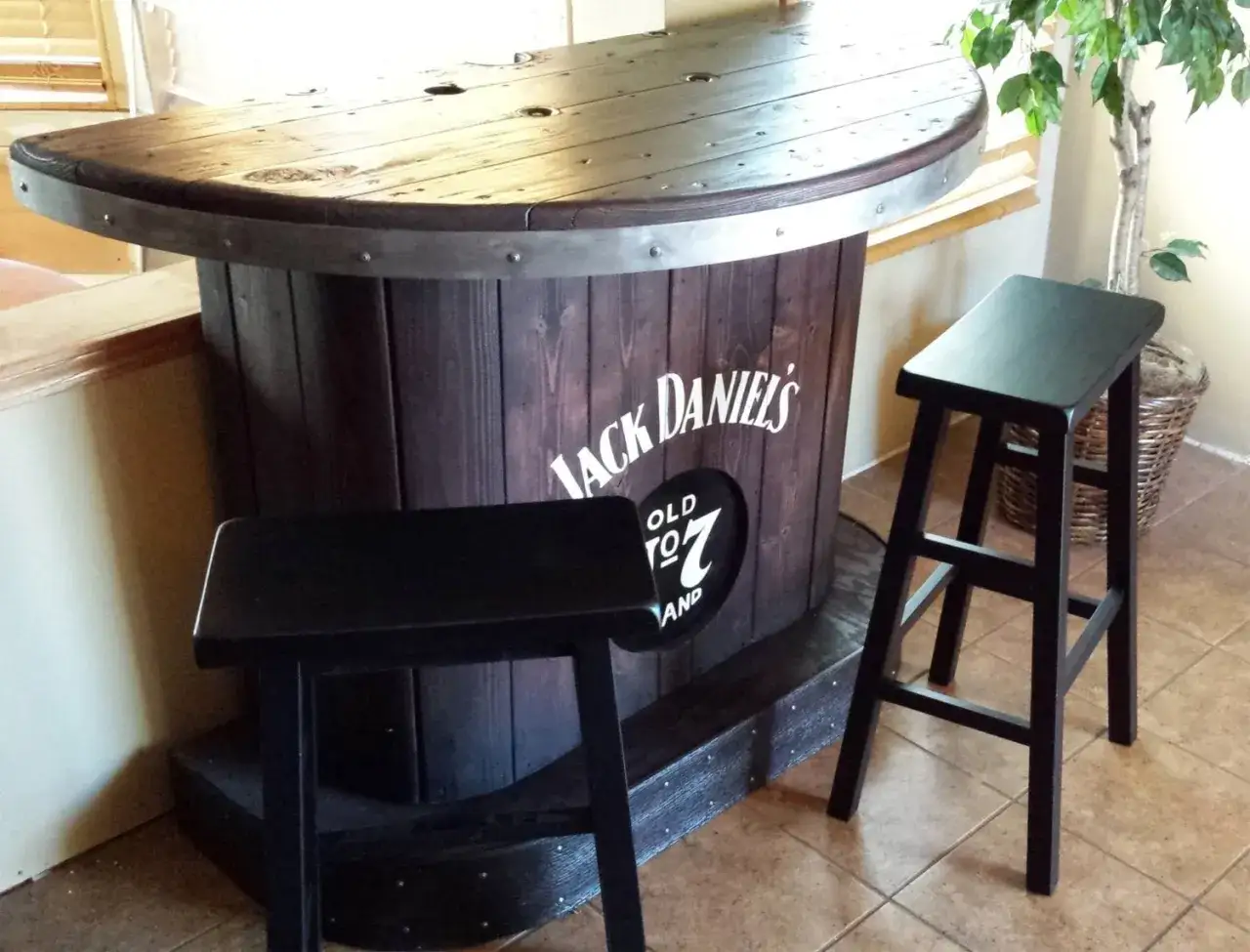Hemmagjord bar i form av en tunna med Jack Daniels-logga. Tv&aring; svarta barstolar st&aring;r framf&ouml;r.