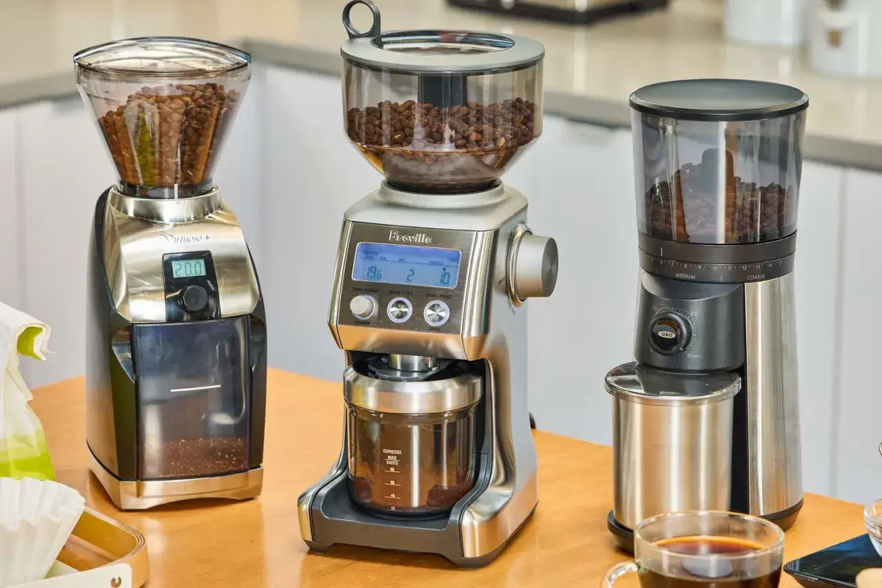 Tre kaffekvarnar redo att mala f&auml;rskt kaffe till espressomaskinen. En kopp kaffe st&aring;r redo.