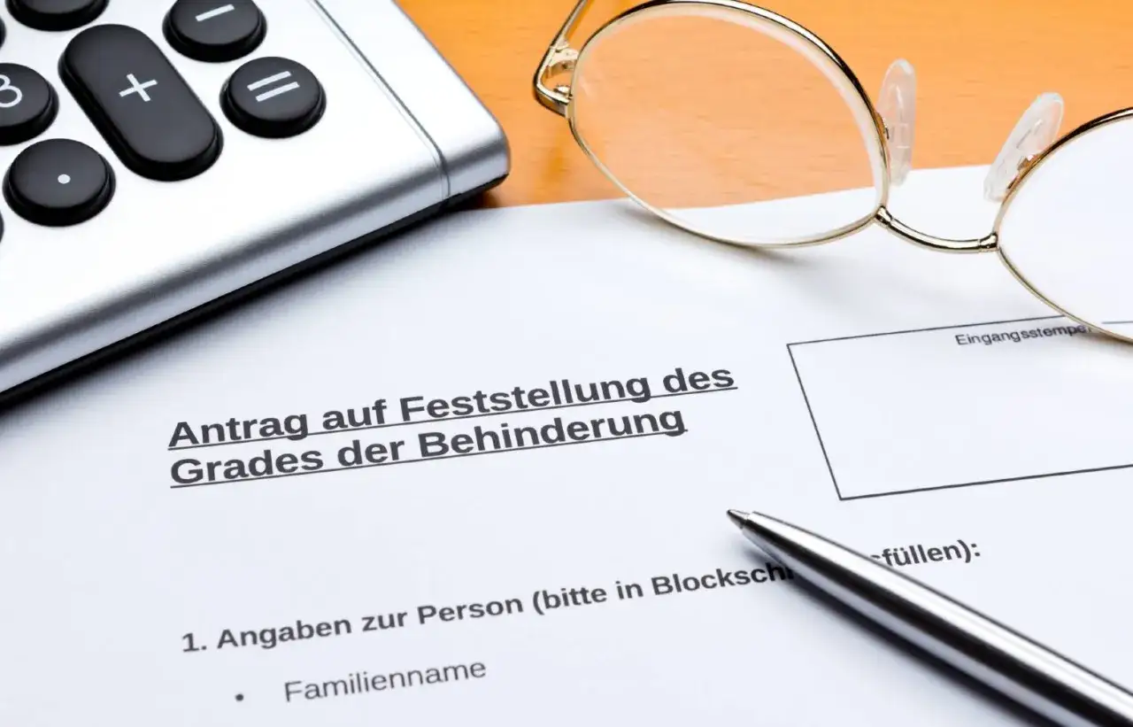 Antrag auf Feststellung des Grades der Behinderung. Ein Taschenrechner, Brille und Stift liegen bereit, um die Formulare f&uuml;r schwerbehinderung diabetes typ 2 und bluthochdruck auszuf&uuml;llen.