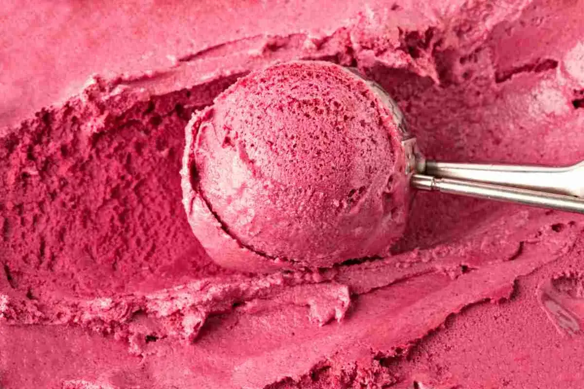 Gelato rosa cremoso, appena prelevato con un porzionatore. Scopri come rendere cremoso il gelato fatto in casa per un risultato perfetto.