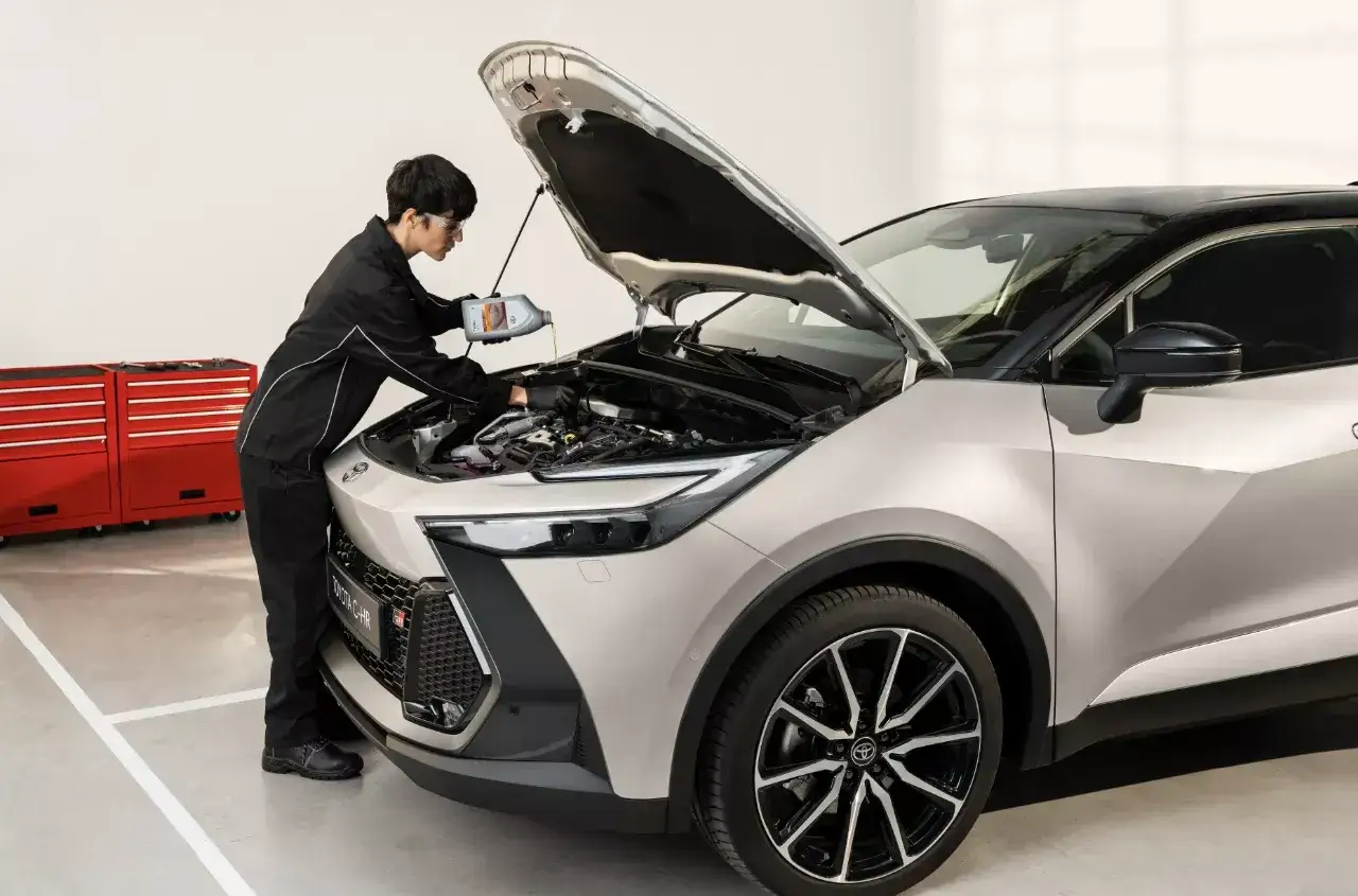 Mechanik wlewa olej do silnika Toyoty. Sprawdź nasz toyota serwis gwarancyjny cennik, by poznać szczegóły.