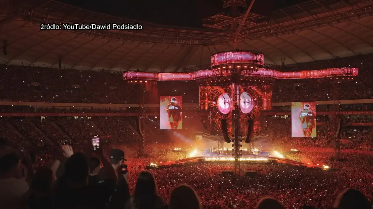 Koncertowa arena rozświetlona na czerwono, tłumy fanów, ekrany pokazujące artystę. Już nie mogę doczekać się **Dawid Podsiadło koncerty 2025**!