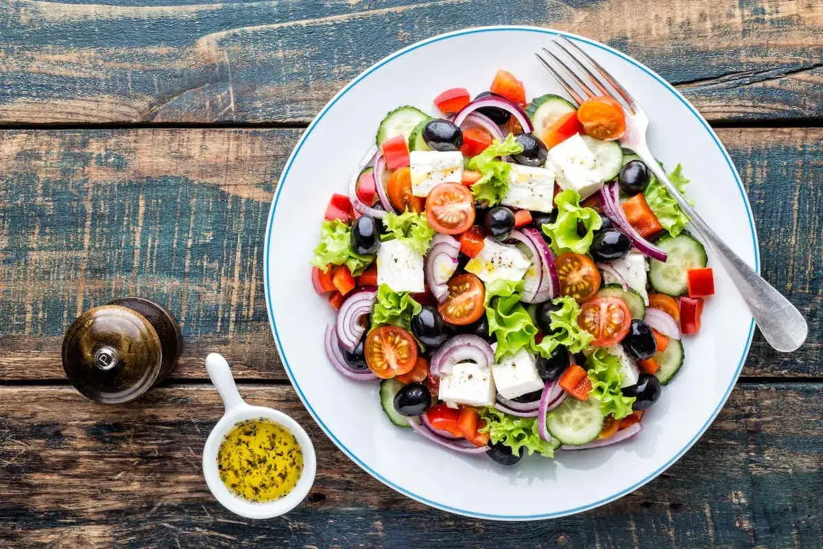 Salade grecque colorée avec feta, olives, tomates, concombre et oignons rouges. Parfait pour une recette fraîche et légère.