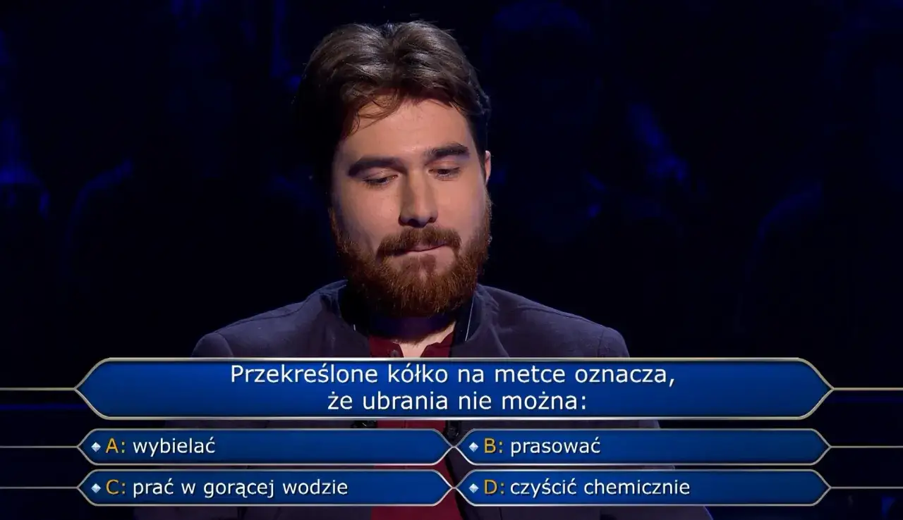 Młody mężczyzna z brodą zastanawia się nad pytaniem z
