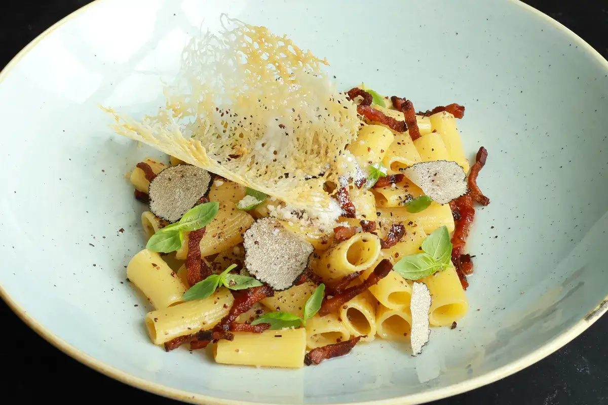 Rigatoni z chrupiącym guanciale, czarną truflą i parmezanową dekoracją. Pyszna gricia w eleganckim wydaniu.