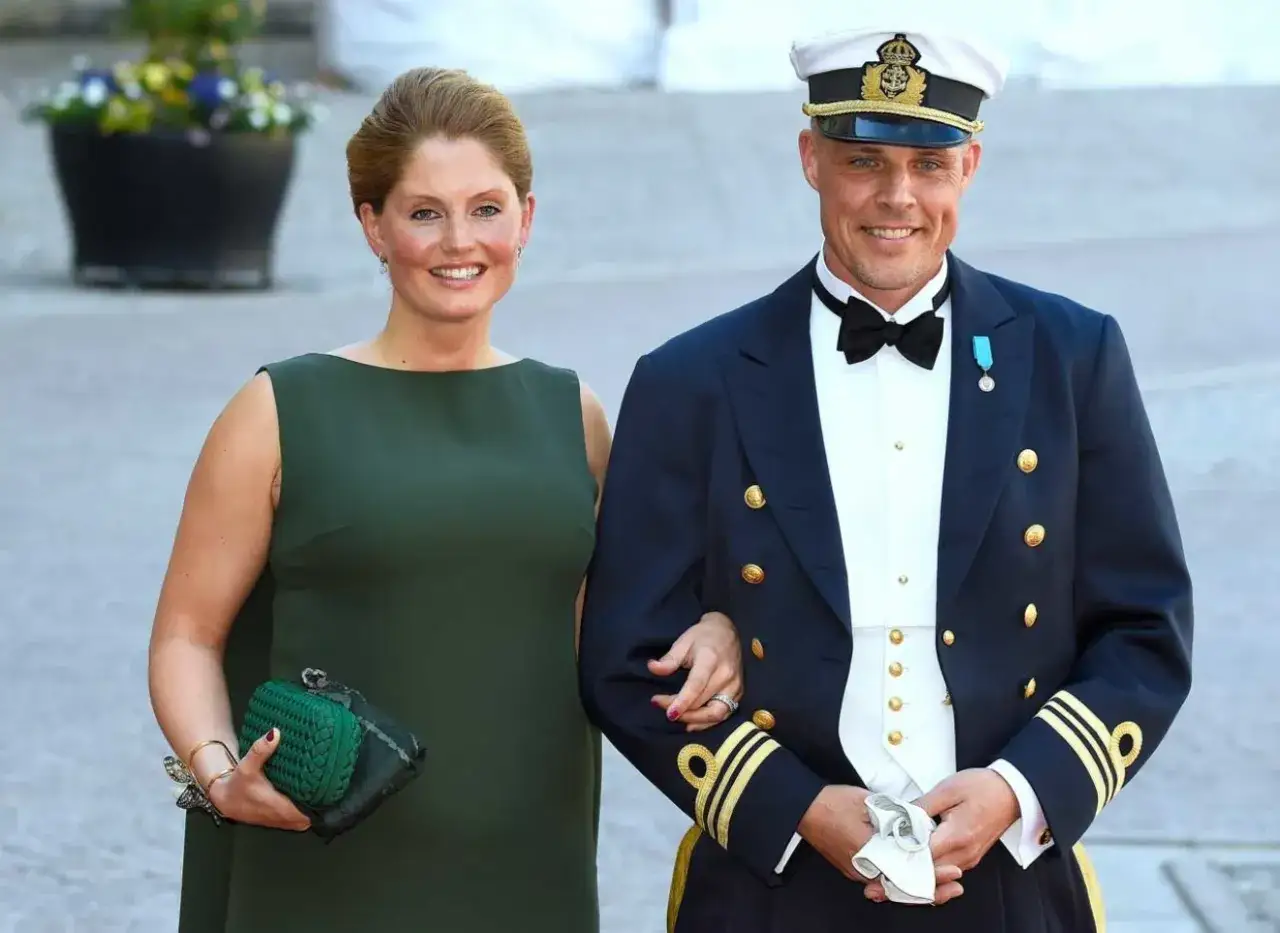 Sian Persson i gr&ouml;n kl&auml;nning med en man i flott uniform.